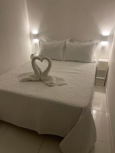 een bed met twee hartvormige handdoeken erop bij Caroá Piranhas Suítes in Piranhas