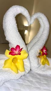 a towel shaped like a heart on a bed with flowers at Caroá Piranhas Suítes in Piranhas