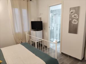 a bedroom with a bed and a tv and a balcony at Affittacamere Ca der Culunellu in Soviore