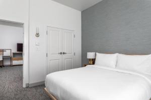 1 dormitorio con 1 cama blanca grande y armario en TownePlace Suites By Marriott Orlando Southwest Near Universal, en Orlando