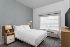 a hotel room with a bed and a window at TownePlace Suites By Marriott Orlando Southwest Near Universal in Orlando