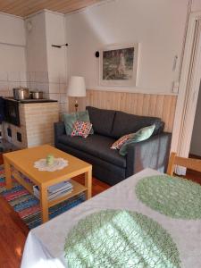 un soggiorno con un divano e un tavolo di Ilmastoitu kesämökki Askolassa lähellä Porvoota a Askola