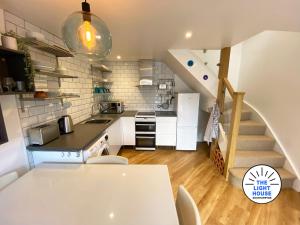 uma cozinha com uma mesa e uma escada num quarto em Welcome to The Light House a tranquil city retreat. em Southampton