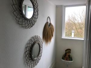 ein Badezimmer mit zwei Spiegeln an der Wand und einem Fenster in der Unterkunft De Witte Handt in Midsland
