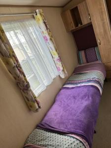 um pequeno quarto com 2 camas e uma janela em Hot tub breaks Fairways Tattershall lakes em Tattershall