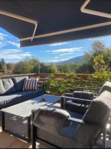 ein Wohnzimmer mit einem Sofa und Stühlen auf einer Terrasse in der Unterkunft Villa Lake House in Mavrovo-Nationalpark