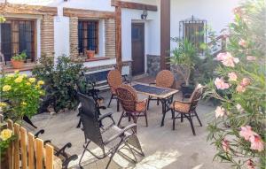 a patio with a table and chairs and flowers at Cozy Home In Baza With Wifi in Baza