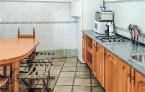 a kitchen with a table and a microwave and a table with chairs at Cozy Home In Baza With Wifi in Baza