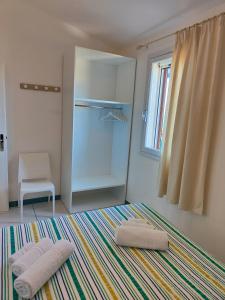 a room with two towels on a bed and a window at Casa Vacanze Miranda in Torre Dei Corsari