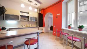 una cocina con paredes rojas y taburetes de bar en Lviv Euro Hostel, en Leópolis