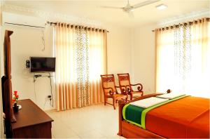 1 dormitorio con 1 cama, mesa y sillas en Ronaka Airport Transit Hotel en Katunayaka