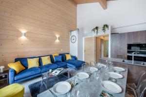Una sala de estar con un sofá azul y una mesa. en Perle De Savoie - Apt B303 - BO Immobilier - remises sur les forfaits de skis Châtel ou Portes du soleil, en Châtel