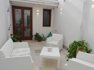 patio con sedie bianche e tavolo bianco di Core a Core Suite a Lizzano