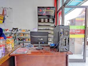 uma loja com um computador num balcão de madeira em SPOT ON 92452 Griya Sandi Homestay Syariah em Banyuwangi