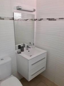 a white bathroom with a sink and a toilet at Studio Colibri Baie-Mahault in Baie-Mahault