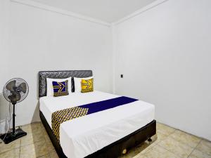 um quarto com uma cama e uma ventoinha em SPOT ON 92452 Griya Sandi Homestay Syariah em Banyuwangi