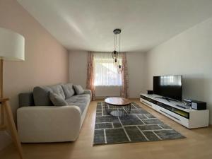 a living room with a couch and a flat screen tv at Appartement Two in Ötztal-Bahnhof