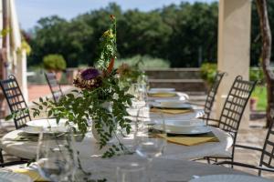 une table avec des assiettes et des verres et une pièce maîtresse de fleurs dans l'établissement Tenuta le Viste - panoramic Villa, à Scandicci