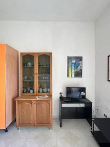 Habitación con armario de madera y escritorio con ordenador. en Casa Vacanze Sant'Orsola, en Trinità dʼAgultu