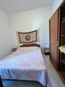 特里尼塔迪亞古圖的住宿－Casa Vacanze Sant'Orsola，一间卧室配有一张床和一个木制橱柜