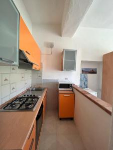 cocina con fogones y encimera de naranja en Casa Vacanze Sant'Orsola, en Trinità dʼAgultu