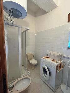 y baño con lavadora y aseo. en Casa Vacanze Sant'Orsola, en Trinità dʼAgultu