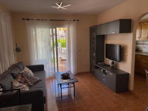 a living room with a couch and a flat screen tv at Los Alamos Somhome in Peniscola
