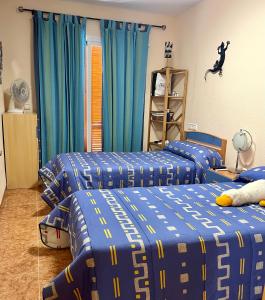 a bedroom with three beds with blue and yellow sheets at Los Alamos Somhome in Peniscola +12 photos