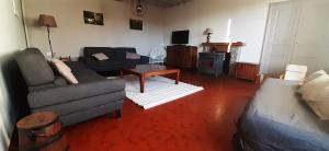 ein Wohnzimmer mit einem Sofa und einem Tisch in der Unterkunft Bienvenue chez Fanny in Bussières