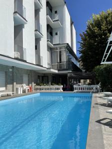 a large swimming pool in front of a building at Hotel Apis in Rimini