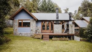 a small house with a blue door and a porch at Modo Villa - Cabaña in Villa La Angostura