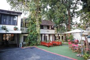 una casa con un patio con sillas y una mesa en El Nogal Casa Hotel, en Asunción