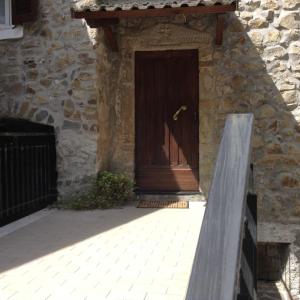 una porta in legno su un edificio in pietra con panca di Casa SILVIO a Sesta Godano