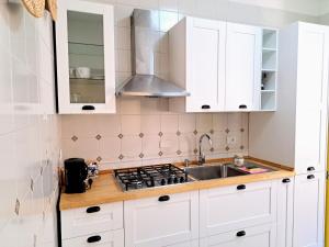 a kitchen with white cabinets and a sink at Castel Sant'Angelo sea view in Licata
