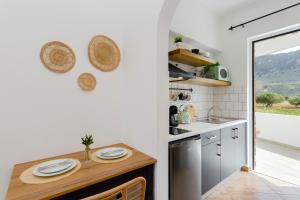 a kitchen with white walls and a wooden counter top at Althea Apartments in Kolimbia