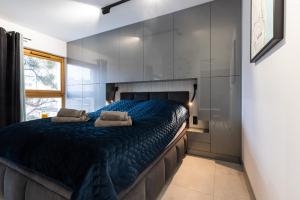 une chambre avec un grand lit avec des draps bleus dans l'établissement AMK Apartament 12 Premium Gdynia Centrum, à Gdynia