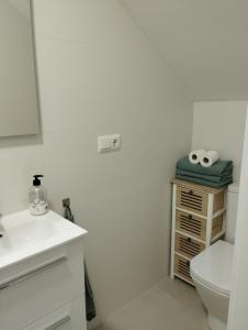 a white bathroom with a toilet and a sink at Casa Eva - Adults Only in Nerja