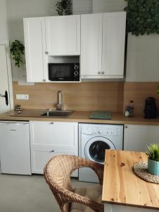 a kitchen with white cabinets and a table and a microwave at Casa Eva - Adults Only in Nerja +36 photos