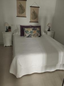 1 dormitorio con 1 cama blanca grande y 2 mesitas de noche en Casa Eva - Adults Only, en Nerja