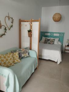 ein Zimmer mit 2 Betten und einem Sofa darin in der Unterkunft Casa Eva - Adults Only in Nerja