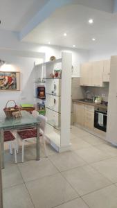 een keuken met witte kasten en een tafel met stoelen bij Appartamento Betty in Porto Santo Stefano