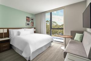 a bedroom with a large white bed and a couch at Element Melbourne Richmond in Melbourne +41 photos