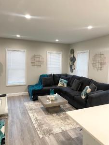 a living room with a black couch and a coffee table at Cozy Short & Suite 4-Bedroom Stay- Minutes to City in Quincy