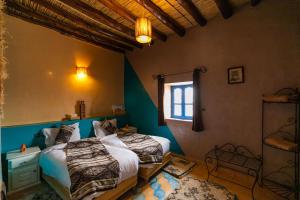 a bedroom with two beds and a window at Dar Duna in Adrouine