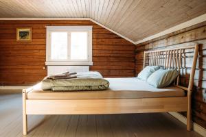 a bed in a wooden room with a window at Breiva Gjestegaard og Glamping in Bø