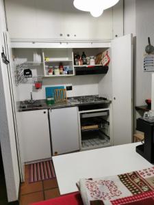 a kitchen with white cabinets and a refrigerator at Appartamento Alba - Residence Montesole in Ponte di Legno +24 photos