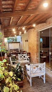 a patio with two wooden benches and a brick wall at Hotel Rio in Guarujá