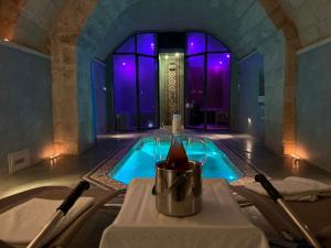 a swimming pool in a room with purple lighting at Palazzo Muro Leccese Relais de Charme & Wellness in Muro Leccese
