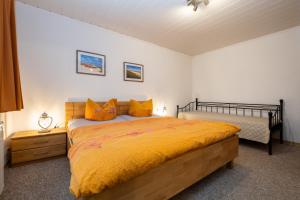 ein Schlafzimmer mit einem großen Bett mit gelber Tagesdecke in der Unterkunft Haus 1 in Ückeritz