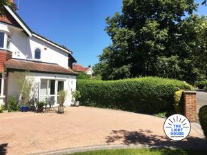 a house with a brick driveway and a hedge at Welcome to The Light House a tranquil city retreat. in Southampton